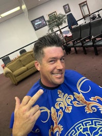 a man giving the peace sign in a barber shop